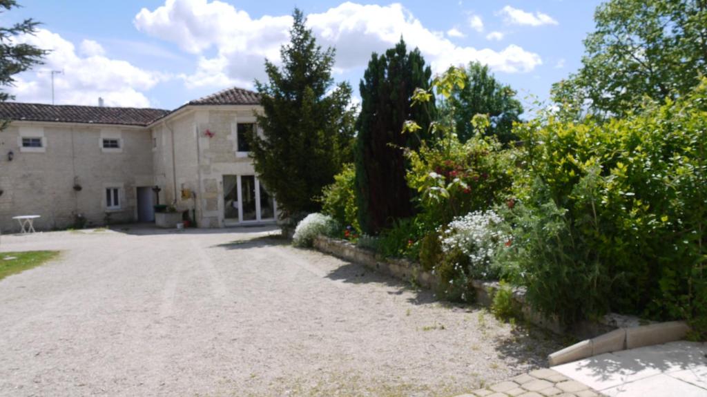 a large stone house with a driveway at Hotel Karina in Jarnac