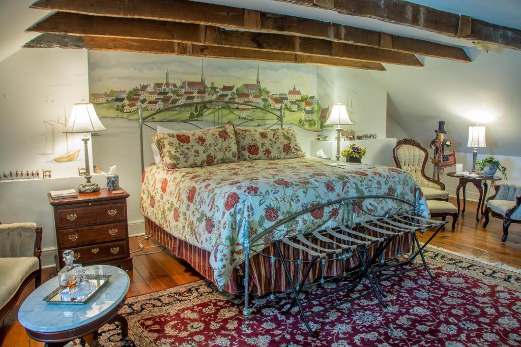 a bedroom with a large bed and a living room at The Richard Johnston Inn & 1890 Caroline House in Fredericksburg