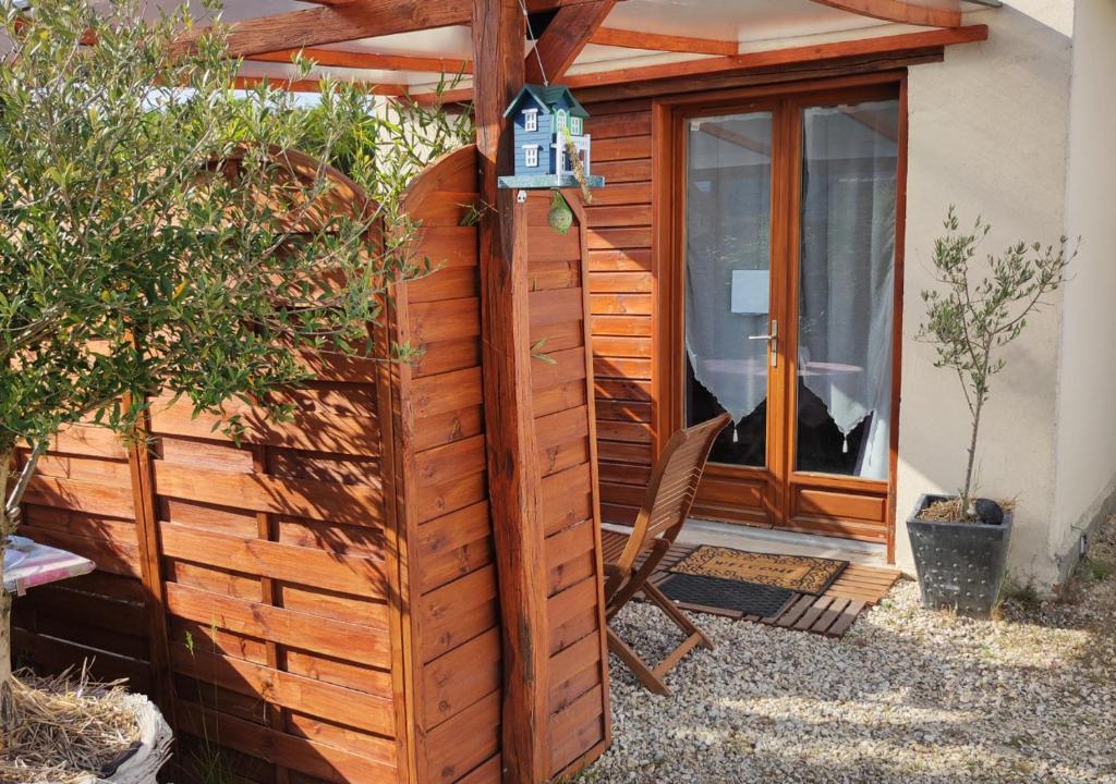 a wooden cabin with a chair next to a door at studio avec terrasse "Le Loup" in Lamotte-Beuvron
