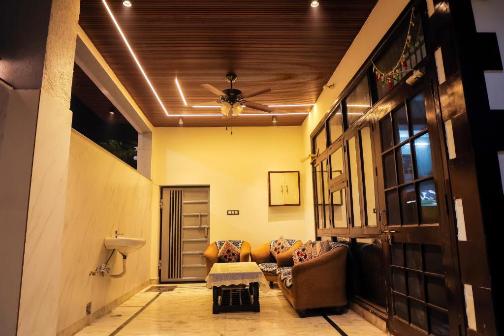 a living room with a couch and a ceiling fan at Anirudh Homestay in Agra