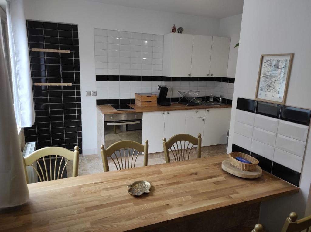 uma cozinha com uma mesa de madeira e cadeiras em résidence luxe césar aeroport tillé 7 personnes em Tillé
