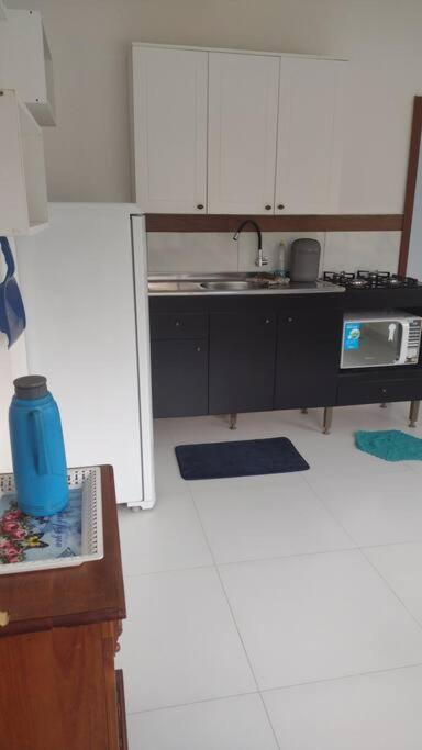 uma cozinha com armários brancos e uma bancada em Apartamento bem localizado em Joinville