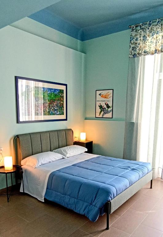 a bedroom with a large bed with blue walls at LE VOCI DELLA FONTANA in La Spezia