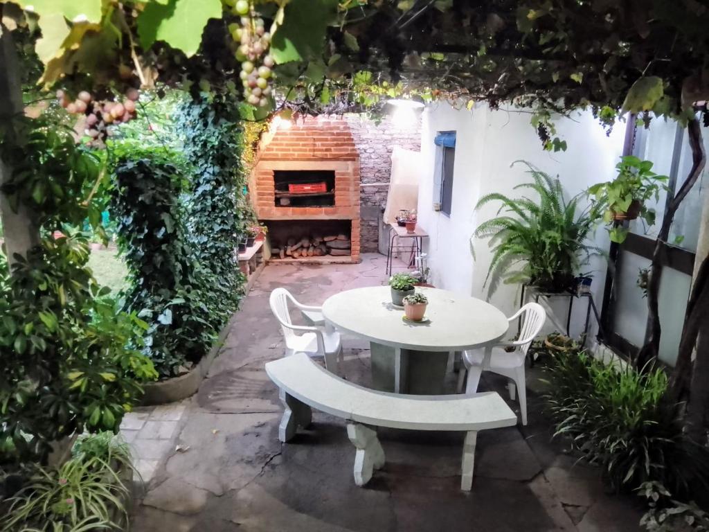 un patio con mesa, sillas y chimenea en "Mi pequeño refugio" - Apartamento Colonia del Sacramento, en Colonia del Sacramento