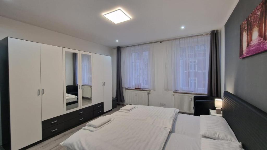 - une chambre avec un grand lit blanc et un miroir dans l'établissement CT Apartment Wurzen, à Wurzen