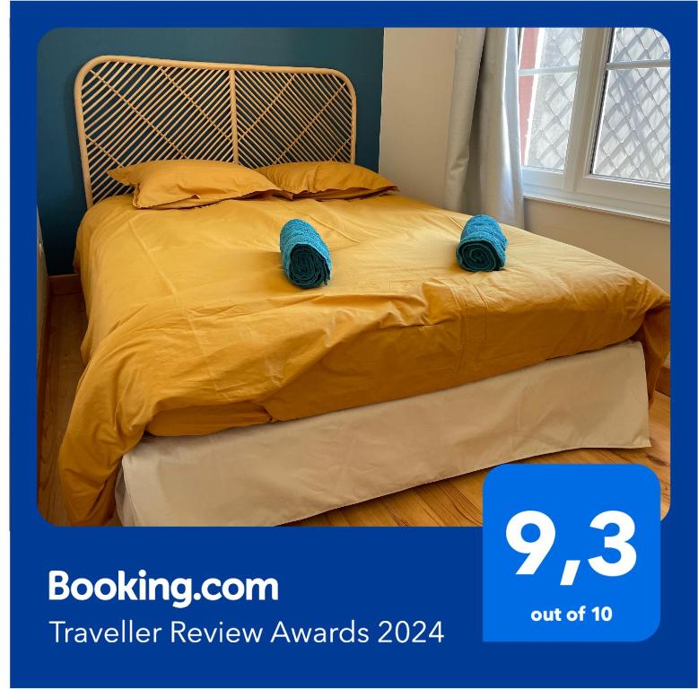 Una cama con dos zapatillas azules encima. en La Glycine en Mers-les-Bains