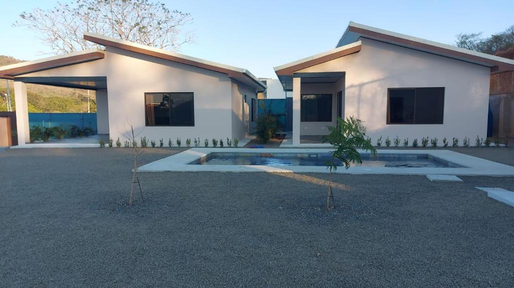 una casa blanca con un patio frente a ella en Villas Brisas de Soley, en La Cruz