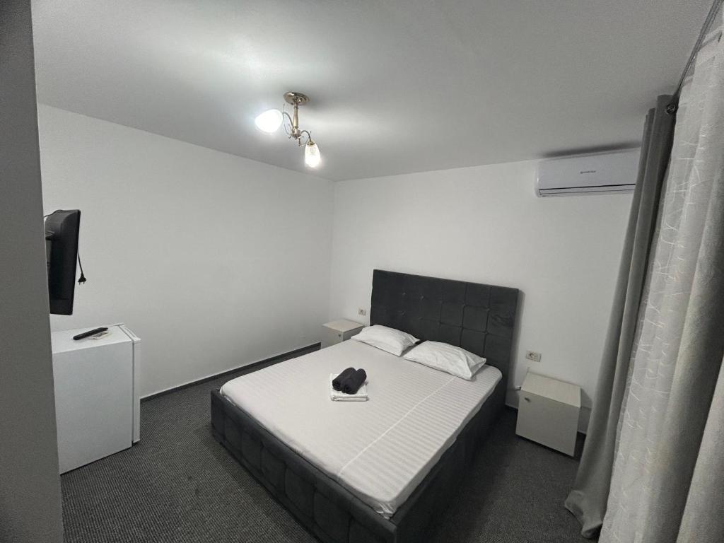 ein kleines Schlafzimmer mit einem Bett mit einem schwarzen Kopfteil in der Unterkunft Casa TIBI și Nico in Eforie Nord