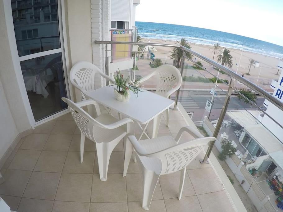 a white table and chairs on a balcony with the beach at BRISA Solo FAMILIAS in Los Mártires