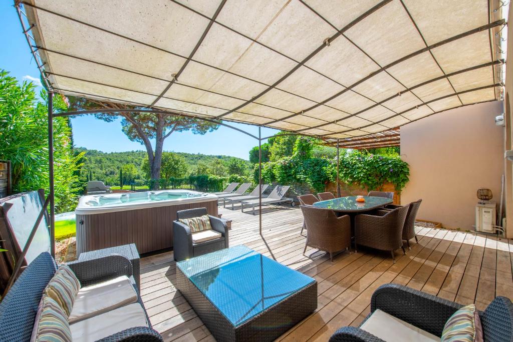 un patio extérieur avec une table, des chaises et un grand parasol dans l'établissement SAINT TROPEZ-Golf view, à Saint-Tropez