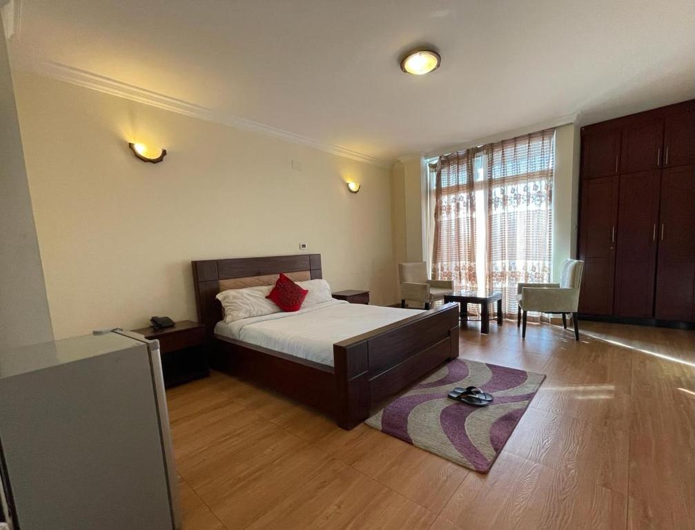 a bedroom with a bed and a table and a chair at Filimon Guest House in Addis Ababa