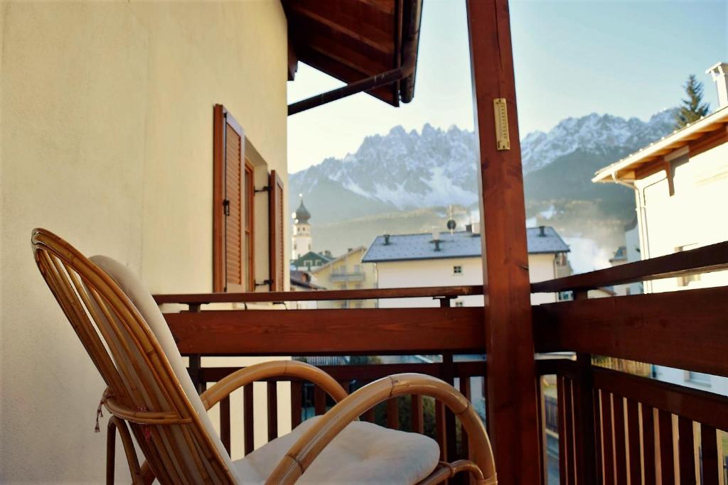 balkon z 2 krzesłami i widokiem na góry w obiekcie A un passo dal...centro w mieście San Candido