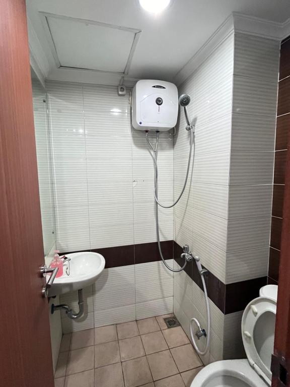 bagno con doccia, lavandino e servizi igienici di VR APARTMENT a Kemirimuka Dua