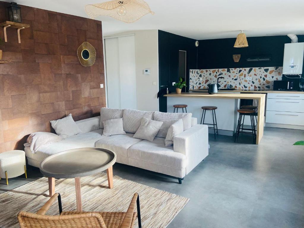 uma sala de estar com um sofá branco e uma cozinha em Appartement centre ville Caen Vaugueux em Caen