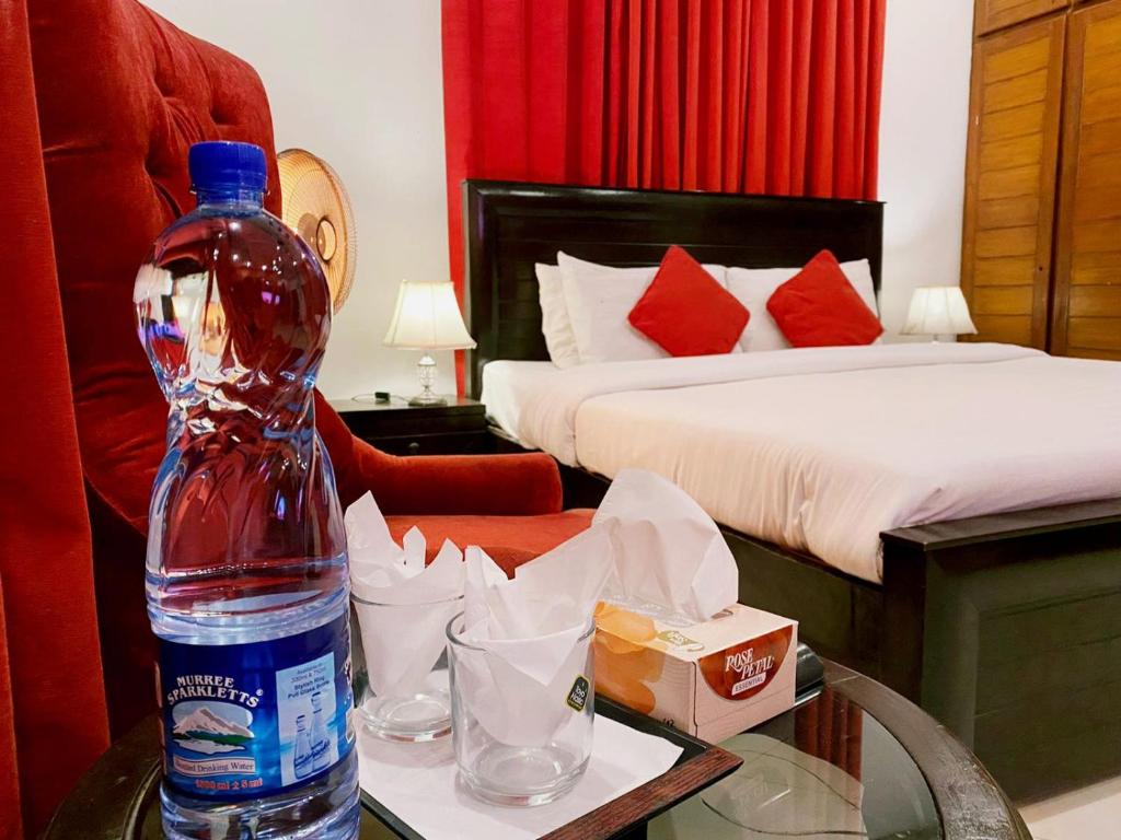 a bottle of water sitting on a table in a bedroom at Harveys Guest House in Islamabad