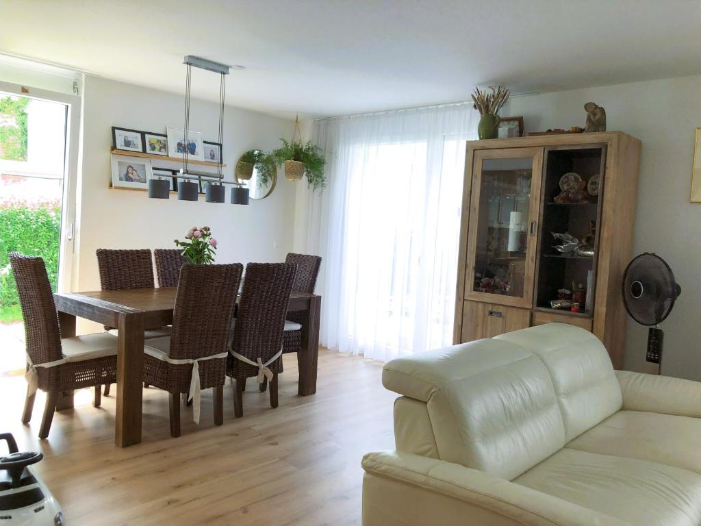 ein Wohnzimmer mit einem Tisch, Stühlen und einem Sofa in der Unterkunft Großes & Modernes Ferienhaus 2 Minuten von Meersburg Innenstadt in Meersburg