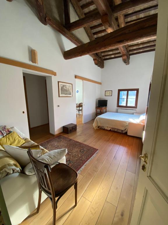 ein Schlafzimmer mit einem Bett und einem Sofa in einem Zimmer in der Unterkunft Agriturismo Barchessa in Este