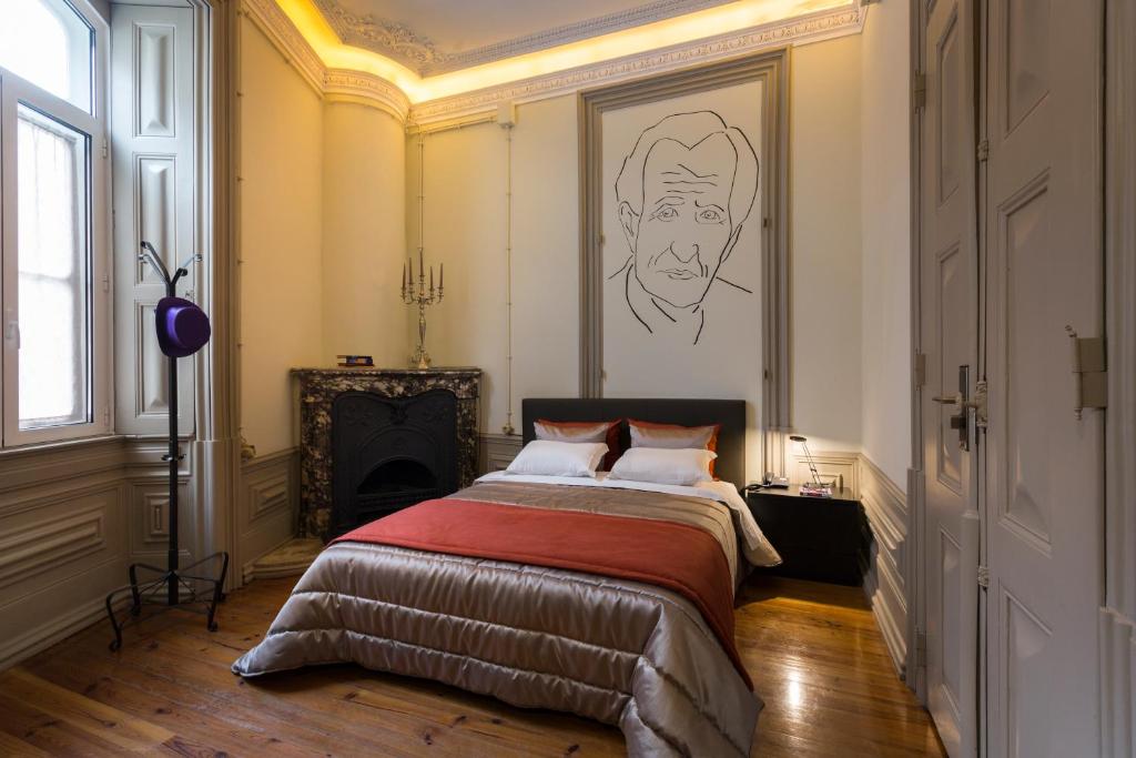 Serenata Hotel & Hostel Coimbra في كويمبرا: غرفة نوم بسرير مع لوحة على الحائط
