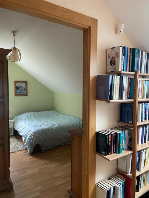 a bedroom with a bed and a book shelf with books at Retour aux sources in Ventron