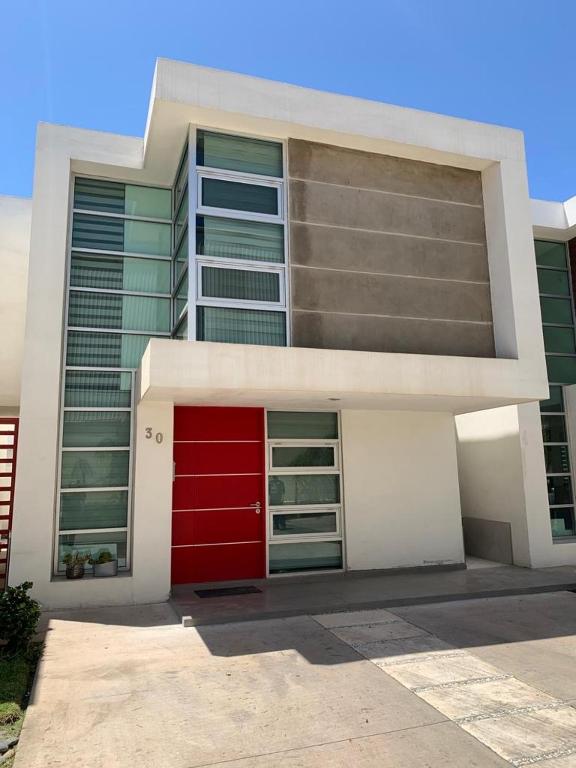 ein Gebäude mit einer roten Tür davor in der Unterkunft Home in Ensenada close to beach in Ensenada