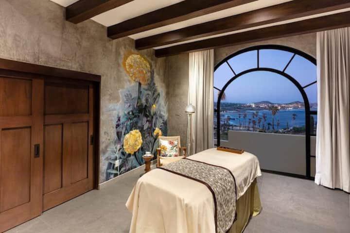 a bedroom with a bed and a large window at VISTA ENCANTADA AT HACIENDA ENCANTADA & SPA RESORT- apartment in Cabo San Lucas