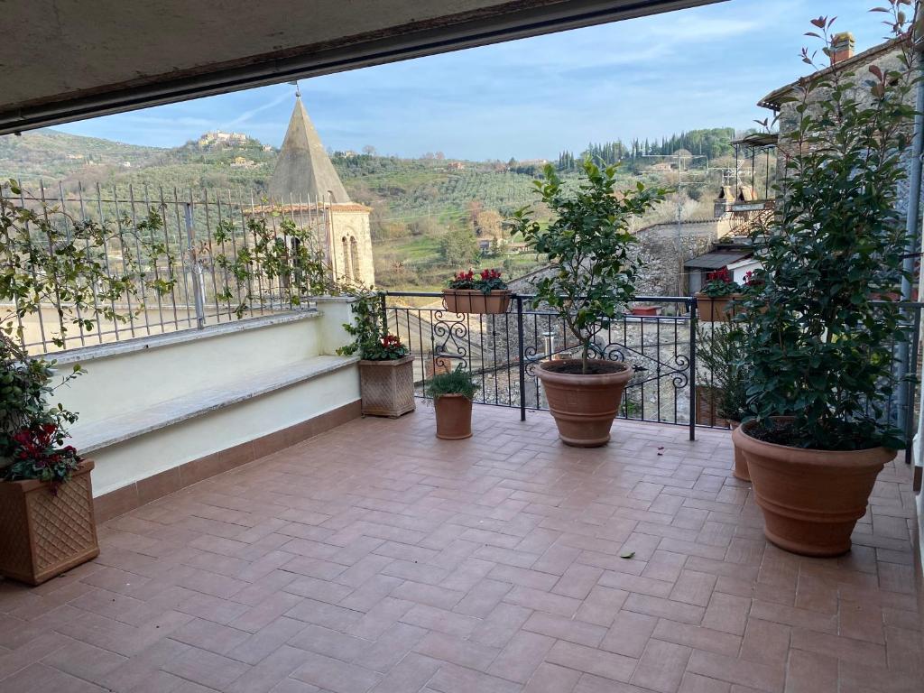 Casa Vacanze Sharazad في Bocchignano: شرفة مع نباتات الفخار وإطلالة على المدينة