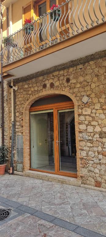 un edificio de ladrillo con puerta de cristal y balcón en Casa DON PEPPE, en Taormina