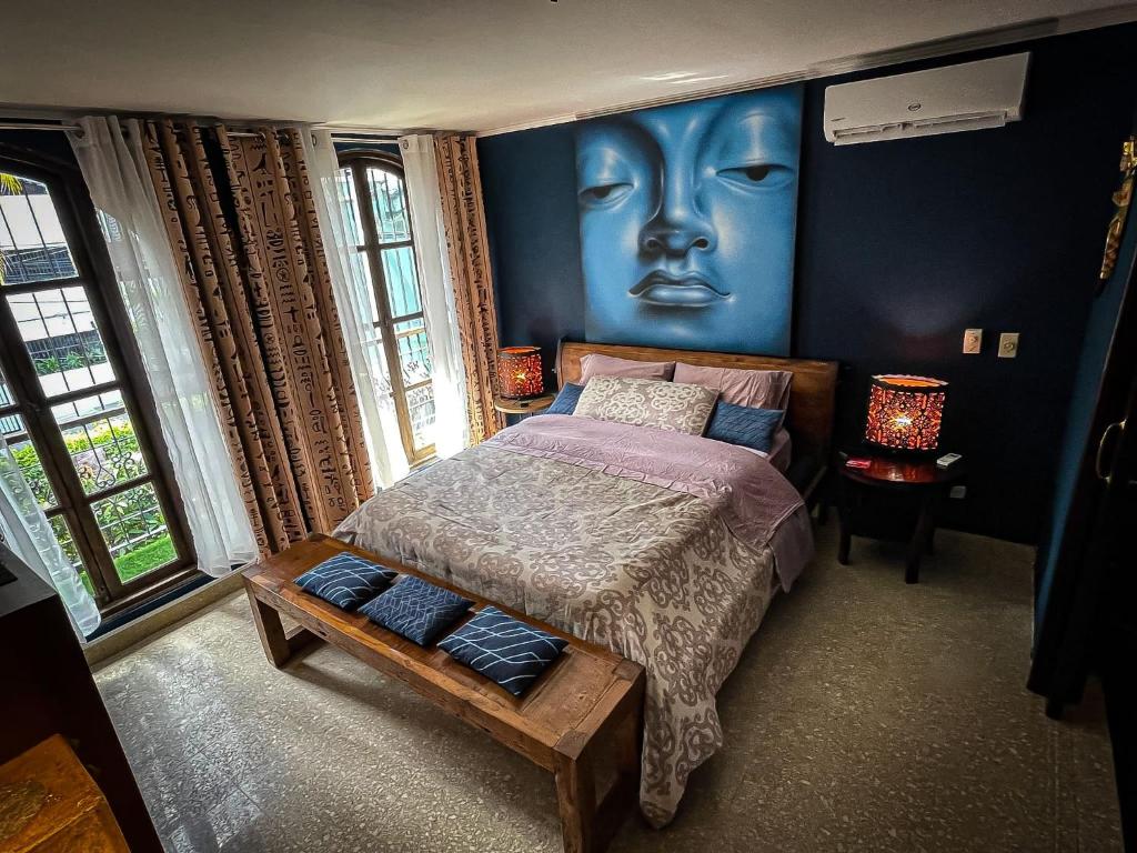 um quarto com uma cama com uma cara pintada na parede em 54 Street East near to F&F Tower em Cidade do Panamá