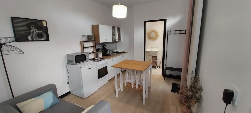 uma pequena cozinha com uma pequena mesa e um fogão em Studio indépendant em Laval