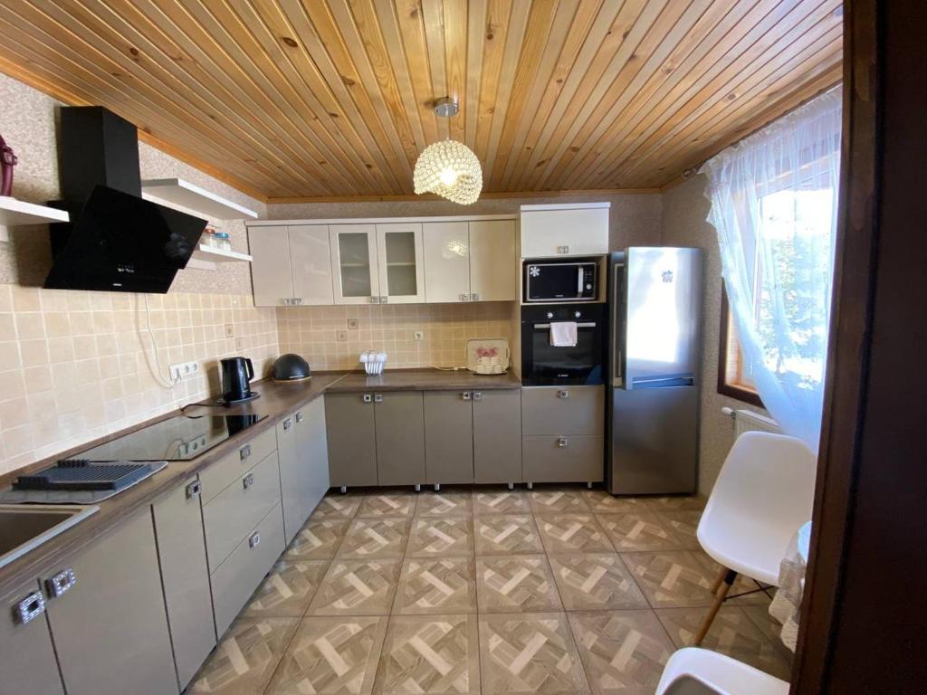 uma cozinha com armários brancos e um frigorífico em На Закуті em Mykulychyn