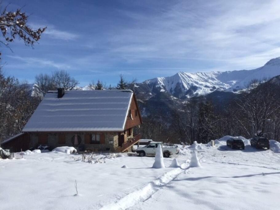 a cabin in the snow with mountains in the background at promo derniere minute Les Sybelles 12-17 fev chalet 12 personnes 900€ (dispo de suite) in Villarembert