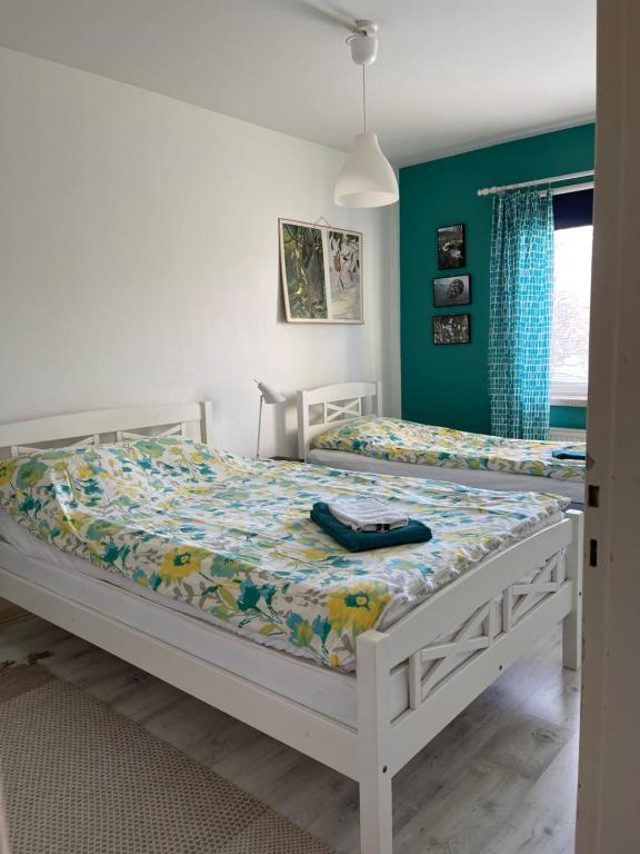 2 camas individuales en un dormitorio con paredes verdes en Jokioinen-Forssa apartment 48m2, en Jokioinen