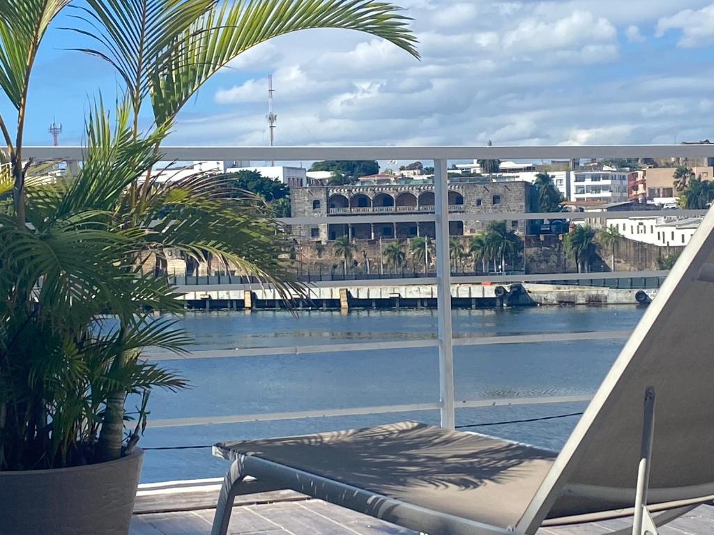 a balcony with a bench and a view of the water at Apartamento Frente a la Zona Colonial, Santo Domingo in Santo Domingo