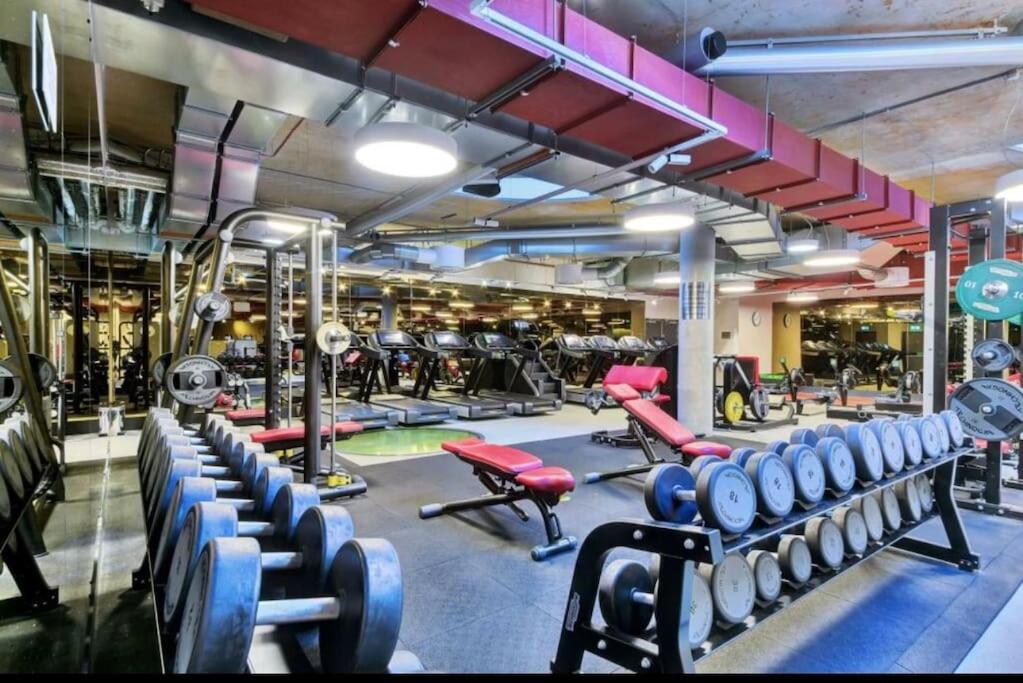 a gym with lots of dumbbells and other equipment at Luxury apartment in Canary Wharf in London