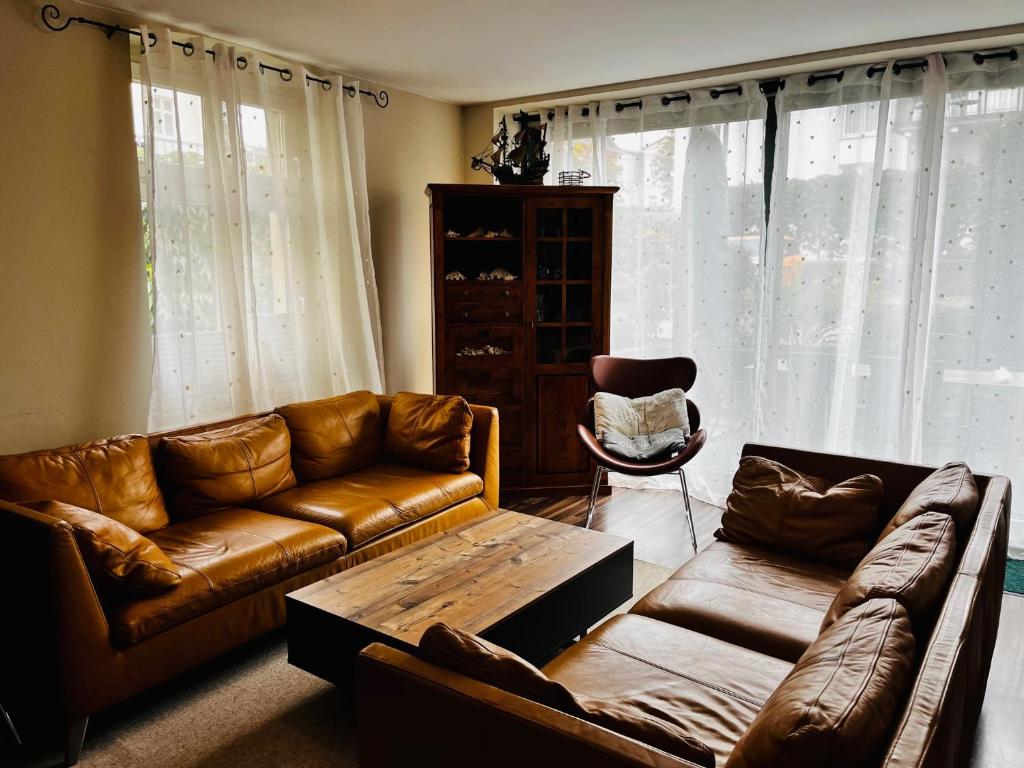 sala de estar con sofá de cuero y mesa de centro en Haus Goodewind en Ahlbeck