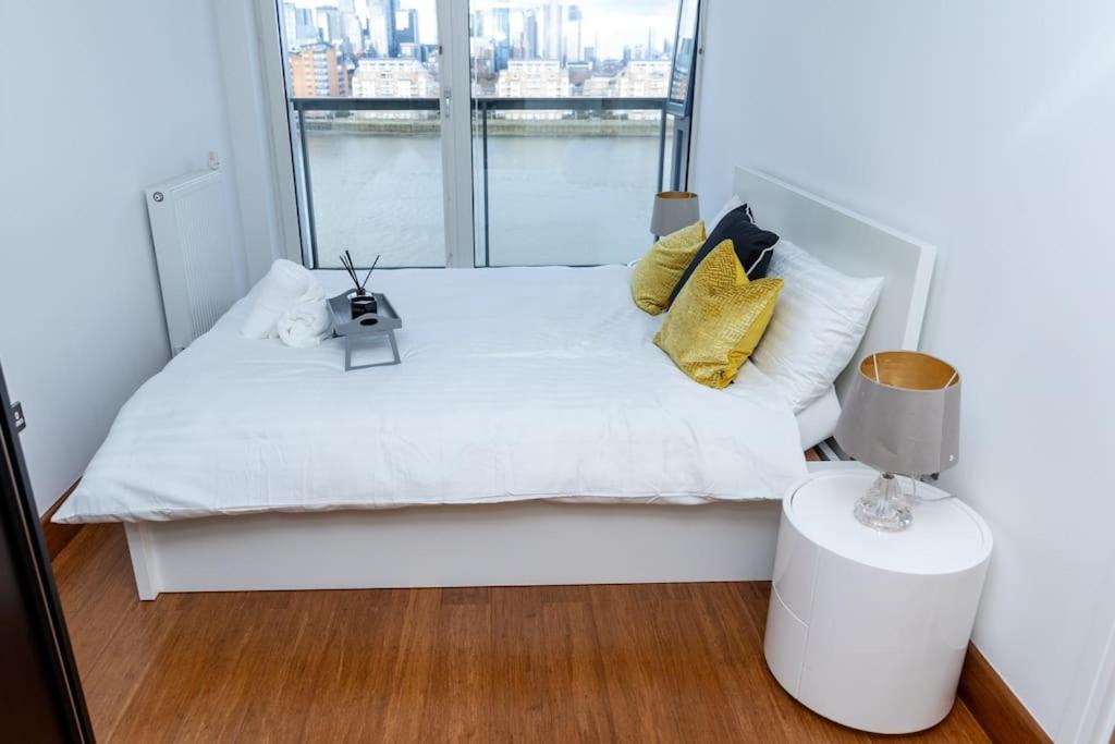 a bedroom with a white bed with a large window at Luxury 2 bed- 2 bath Riverside Haven in London