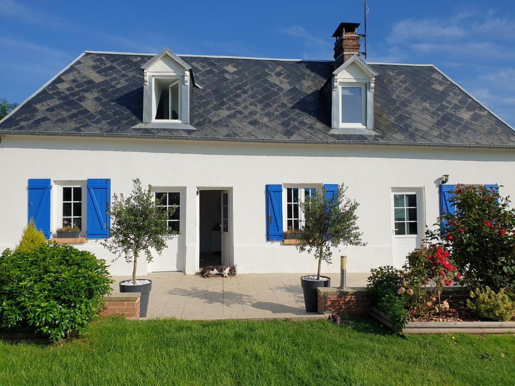 Casa blanca con persianas azules en JenFyz Gîte avec jacuzzi à la campagne, en Conteville