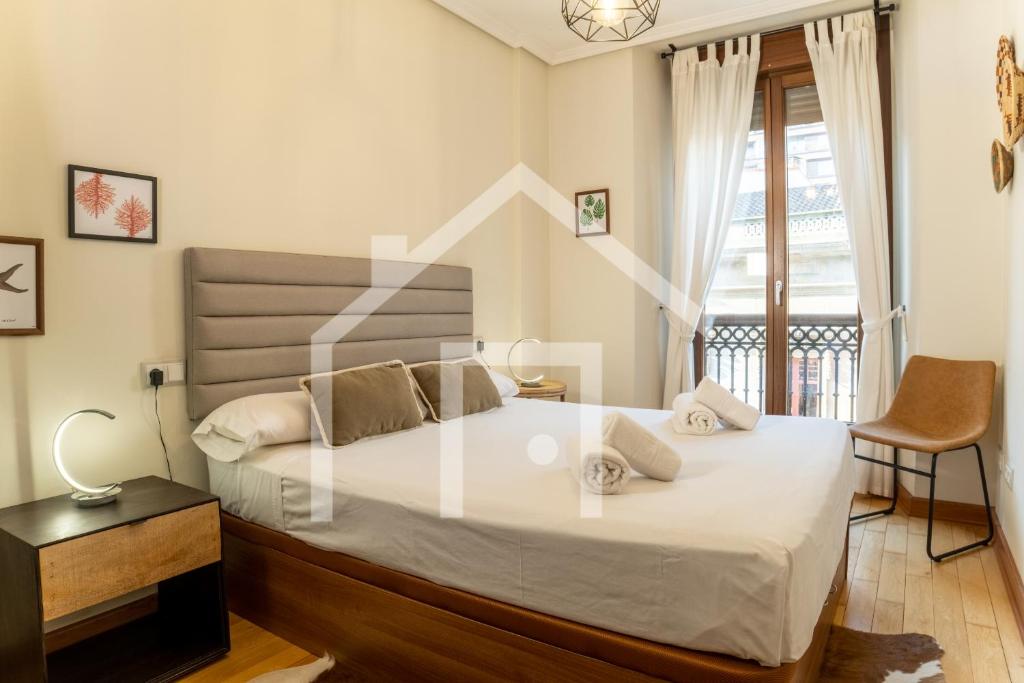 希洪Corrida 37的卧室里有一张白色的大床和一把椅子