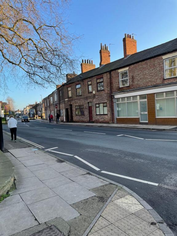 an empty street with buildings on the side of the road at Nunnery lane 3 bedroom house in York
