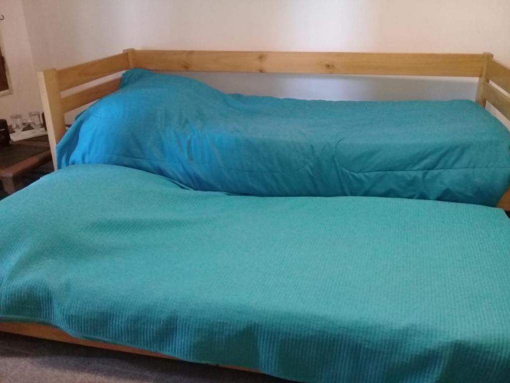 - un lit avec une couverture bleue dans l'établissement Dpto Al Paso, à Zapala