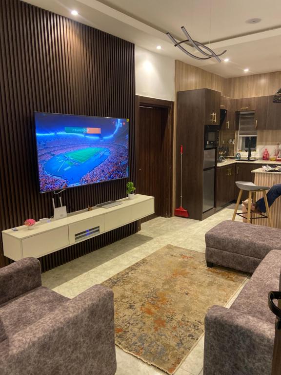 a living room with a large flat screen tv at LTD GRAND APARTMENTS in Wupa