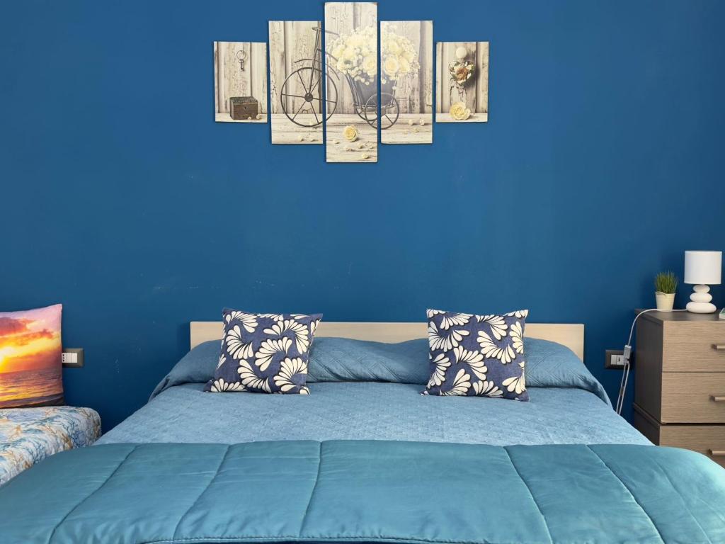 a blue bedroom with a bed and a blue wall at Affittacamere Sa Pardula in Cagliari