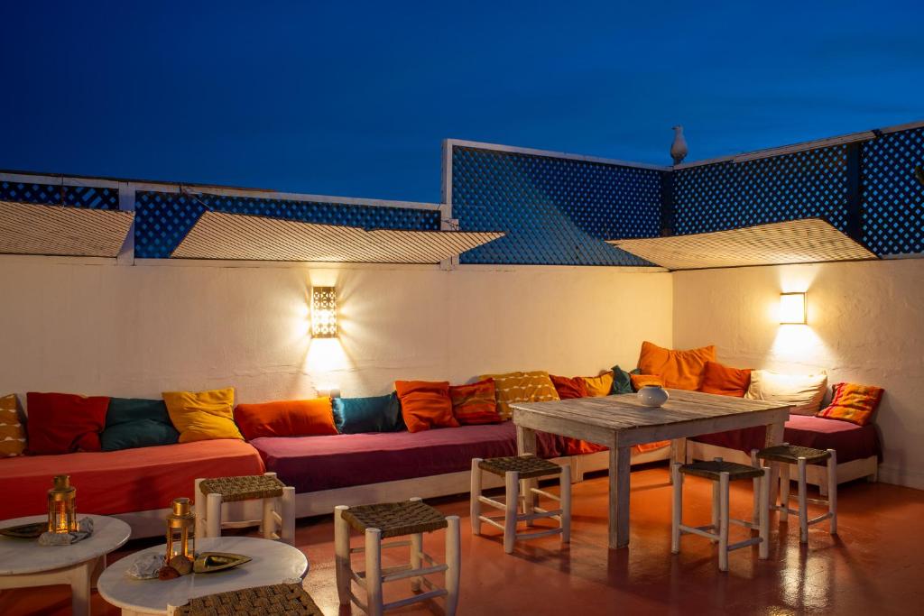 een woonkamer met een bank en een tafel en stoelen bij DAR ORY in Essaouira