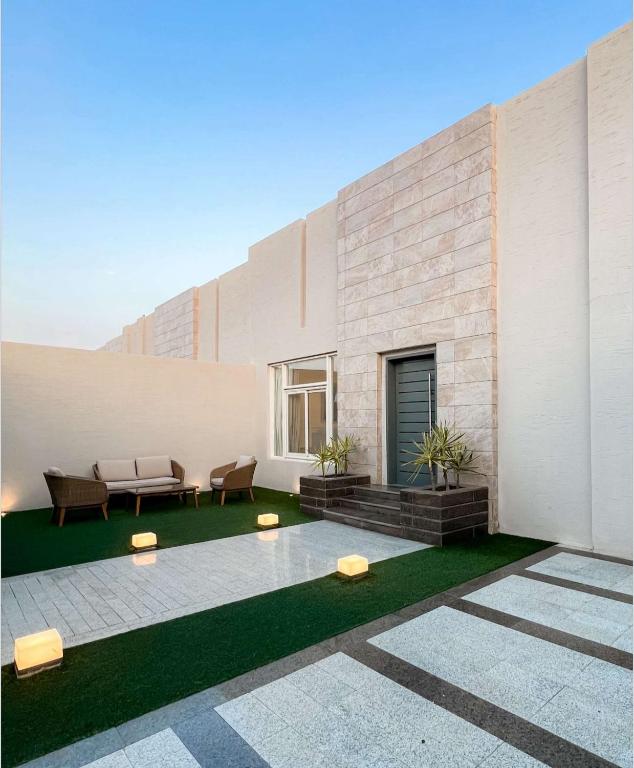 un edificio con un patio con mesa y sillas en شاليهات نفلة en Hajlah