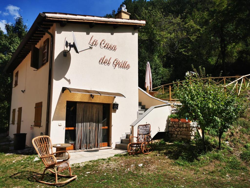 a building with chairs sitting outside of it at LA CASA DEL GRILLO - Valle del Menotre - Rasiglia in Orsano