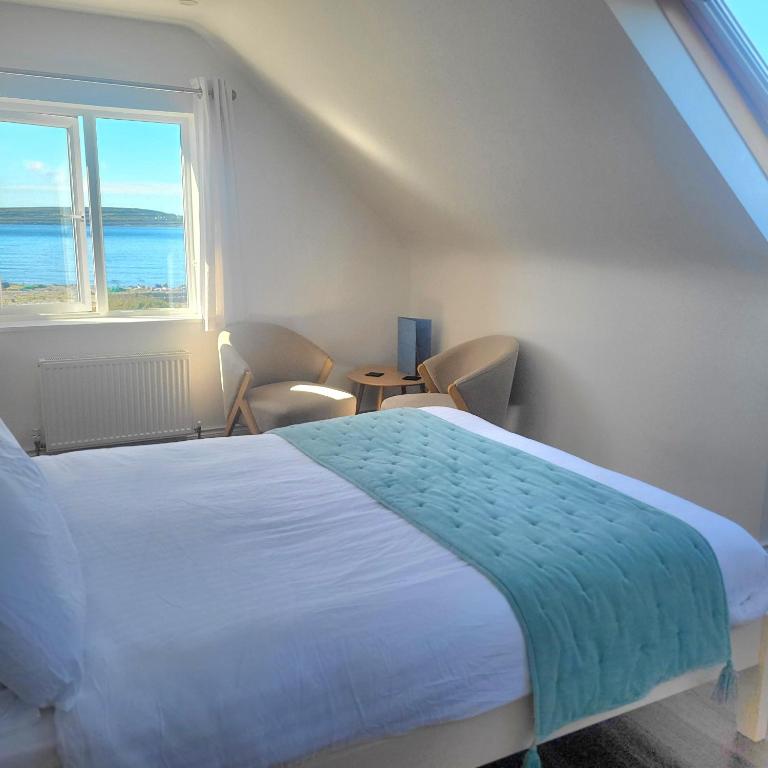 a bedroom with a bed and a large window at An Creagán Rooms in Inisheer