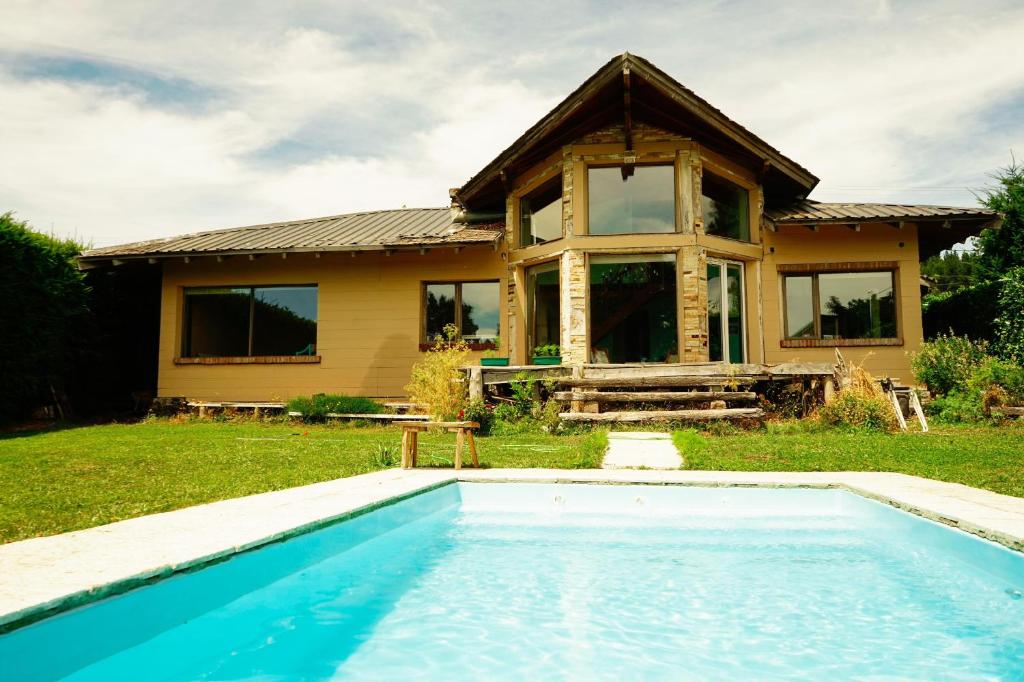 a house with a swimming pool in front of a house at hermosa casa a una cuadra del lago in San Carlos de Bariloche