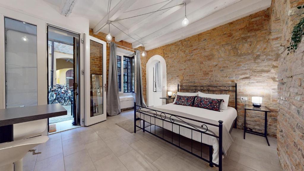 1 dormitorio con cama y pared de ladrillo en La Casetta in colonne, en Milán