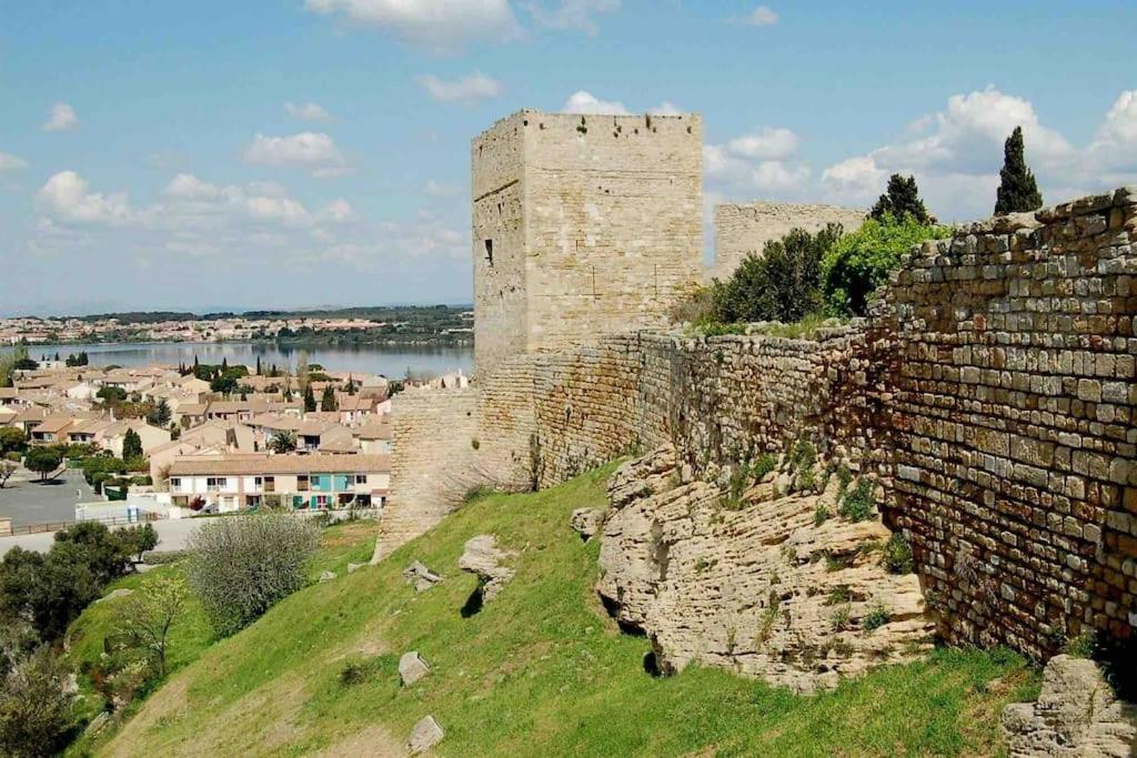 een gebouw bovenop een heuvel met een kasteel bij Appartement tout équipé proche plages in Fos-sur-Mer