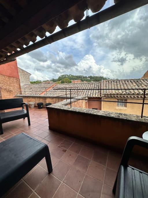 d'un balcon avec un banc et une vue sur un bâtiment. dans l'établissement Appartement centre village, à Roussillon